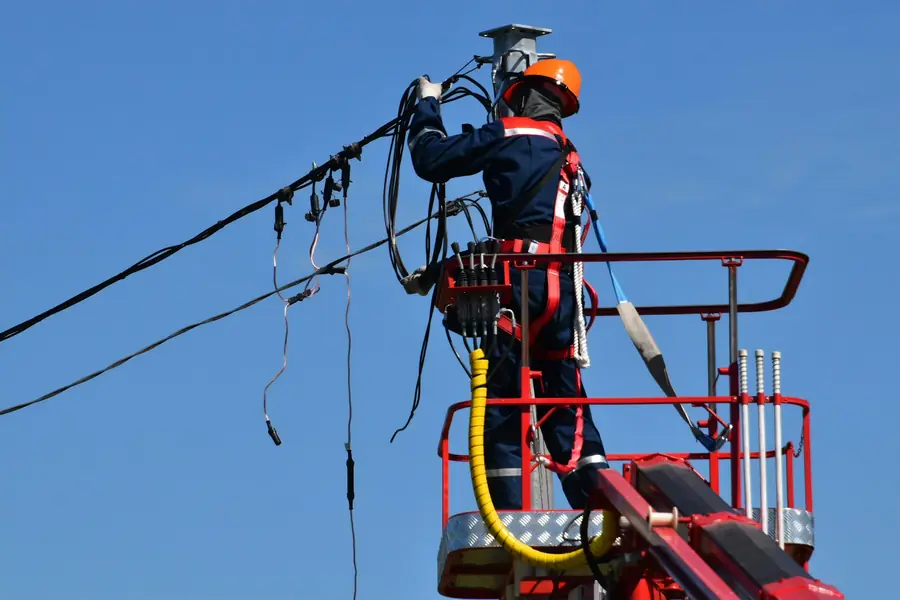 Utility technician repairing overhead lines from a bucket
