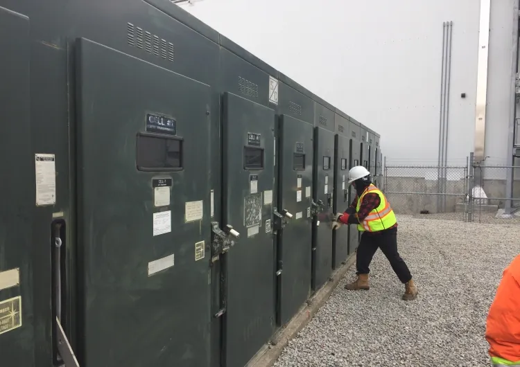 ISCOCA technician in high-visibility PPE servicing medium voltage switchgear at Maple Lodge Farms